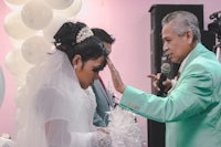 a wedding ceremony with a bride and groom in front of a microphone