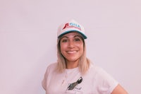 a woman wearing a white t - shirt and a hat