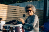 a man in sunglasses playing a conga drum