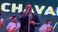 a group of men singing in front of a sign that says chavara