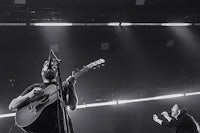 black and white photo of a man playing an acoustic guitar