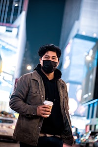 a man wearing a face mask on a city street