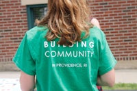 a girl wearing a green t-shirt that says building community