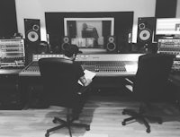 a man sitting at a desk in a recording studio