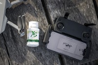 a drone with a bottle of liquid next to it on a wooden table