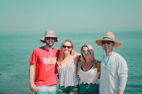 a group of people posing for a photo near the ocean