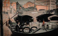 a bride and groom on a gondola in a city