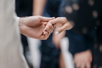 a man and woman holding hands at a wedding